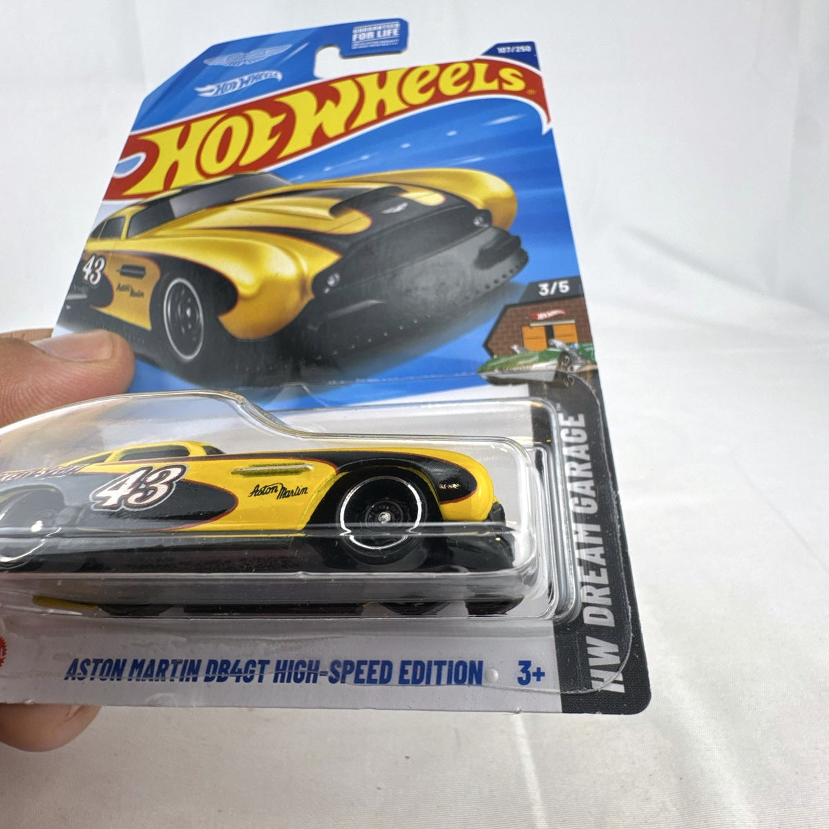 Hot Wheels 1:64 scale yellow Aston Martin DB4GT High-Speed Edition diecast car sealed in original packaging.