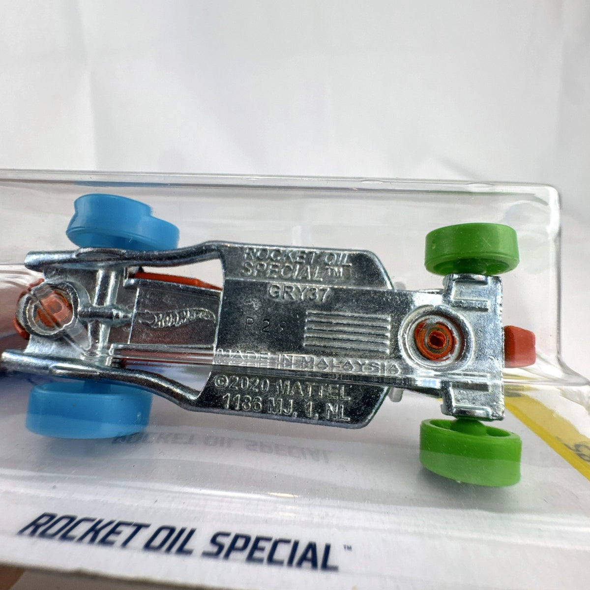 Hot Wheels 1:64 scale Rocket Oil Special diecast car in orange paint splatter from the HW Art Cars series on original card