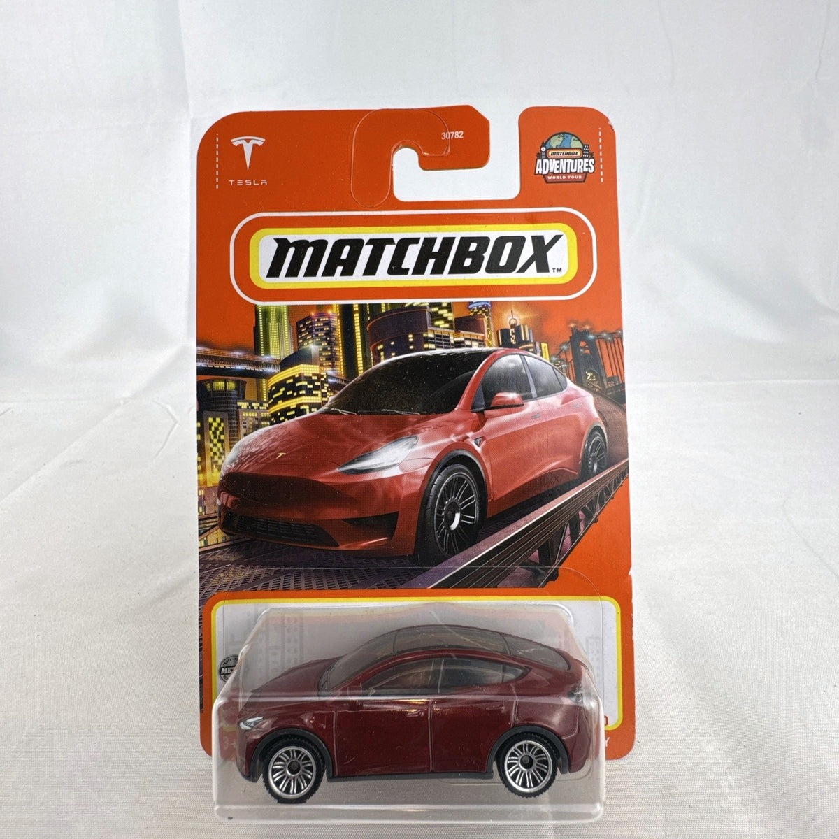 Matchbox 1:64 scale Tesla Model Y diecast toy car in deep metallic red, factory sealed on original card.