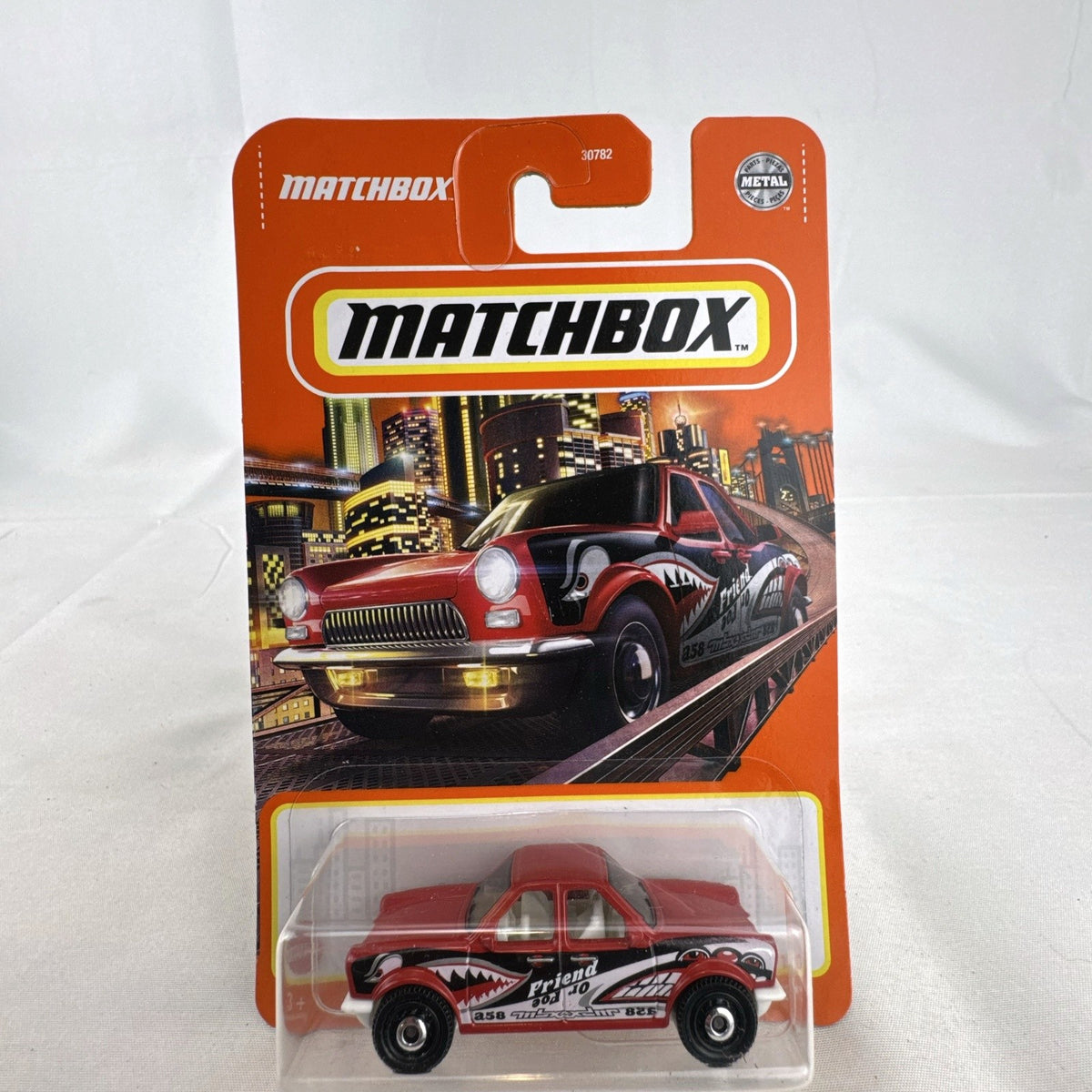 Red Matchbox Push 'N Puller 1:64 scale diecast truck with shark mouth graphics, sealed in original packaging.
