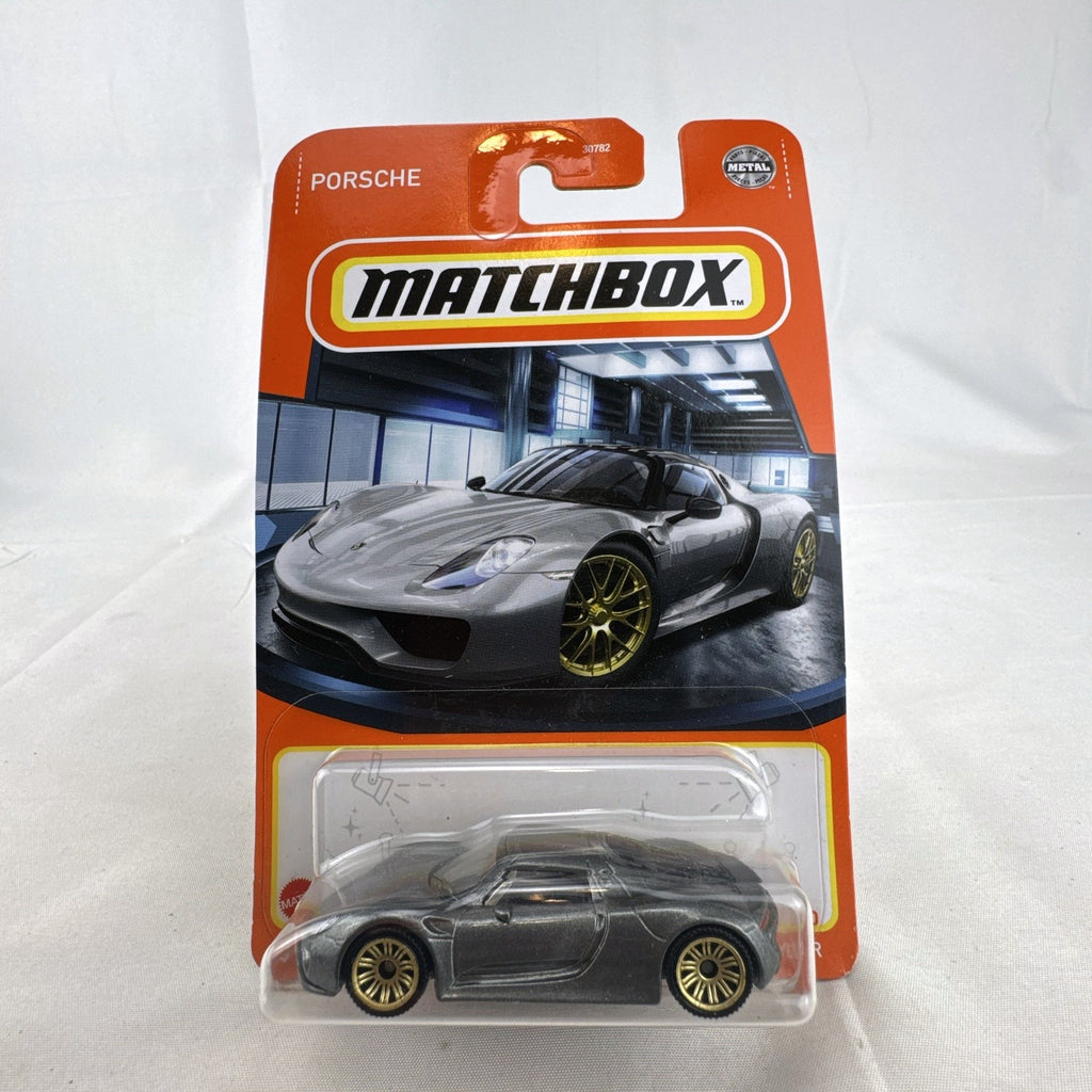Matchbox 1:64 scale Porsche 918 Spyder diecast car in dark metallic grey with gold rims sealed on original card