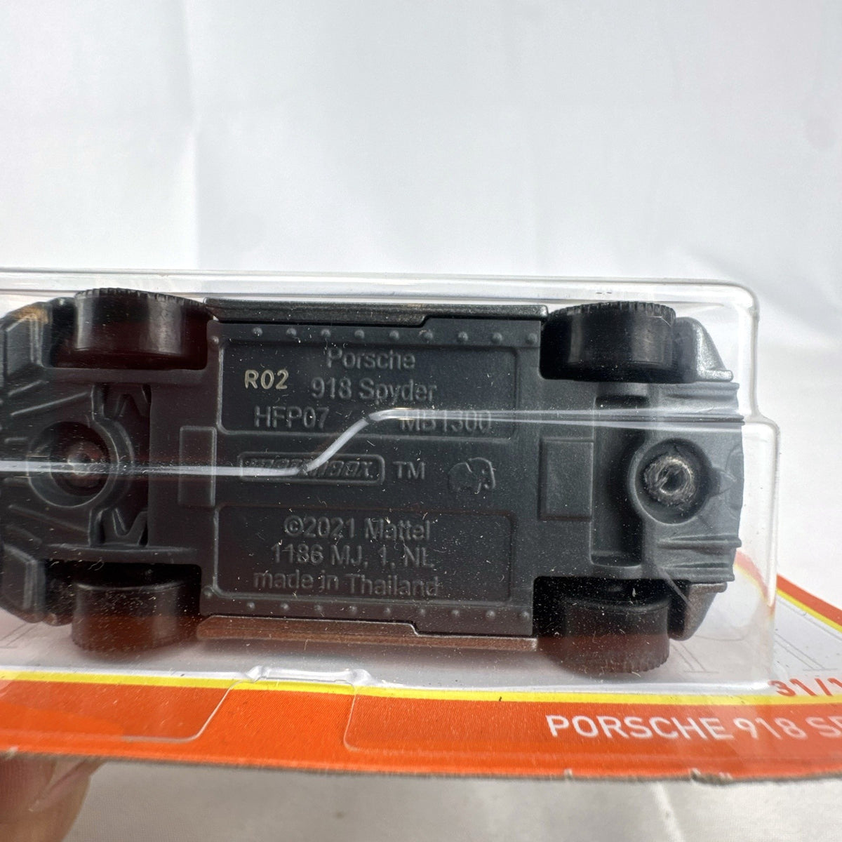 Matchbox 1:64 scale Porsche 918 Spyder diecast car in dark metallic grey with gold rims sealed on original card
