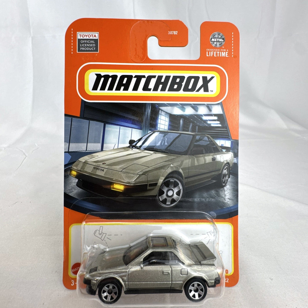 Matchbox 1:64 scale 1984 Toyota MR2 diecast car in metallic gold, factory sealed on card.