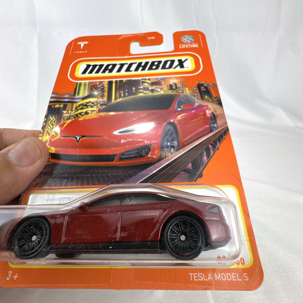 Matchbox 1:64 scale Tesla Model S diecast car in metallic dark red, factory sealed on original cardback