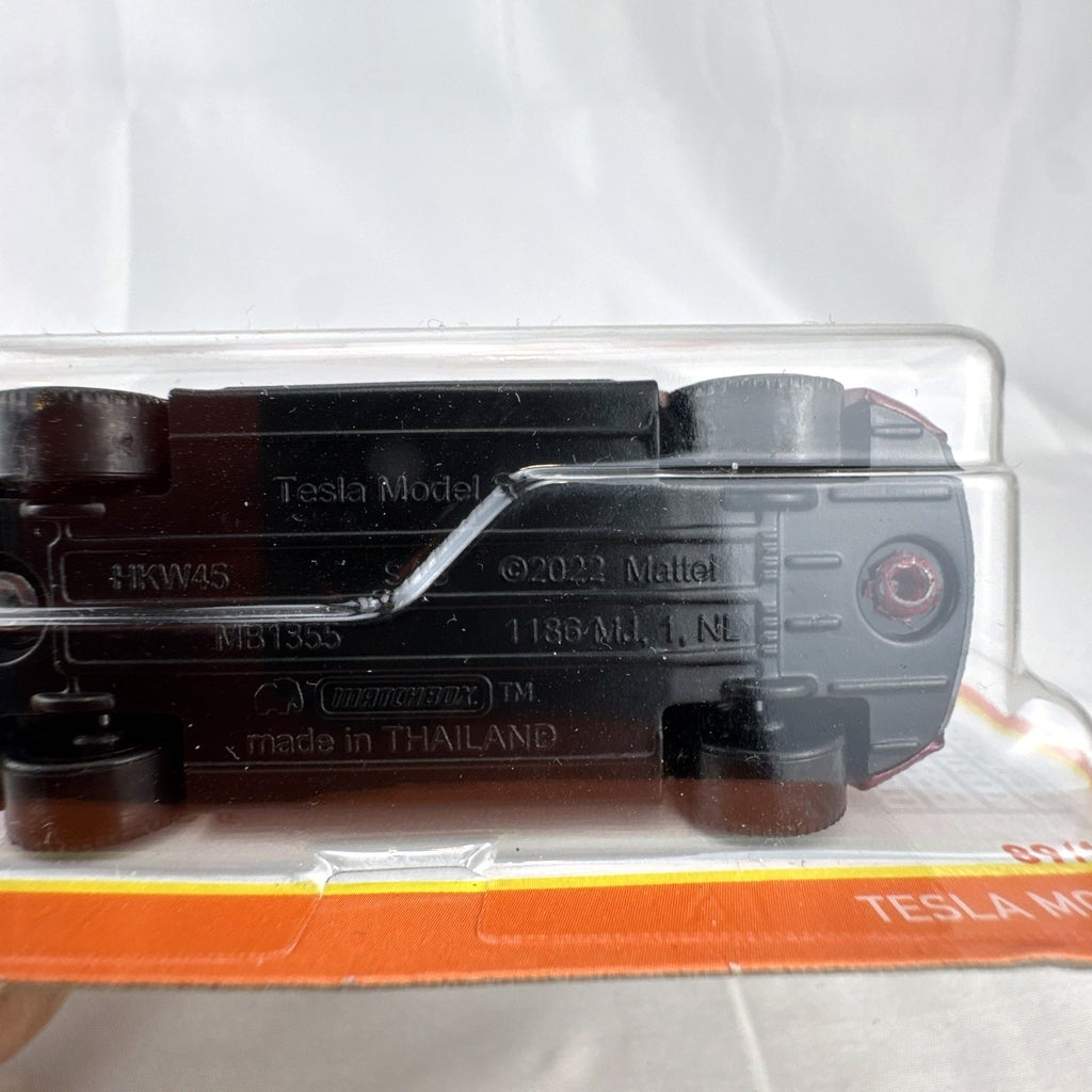 Matchbox 1:64 scale Tesla Model S diecast car in metallic dark red, factory sealed on original cardback