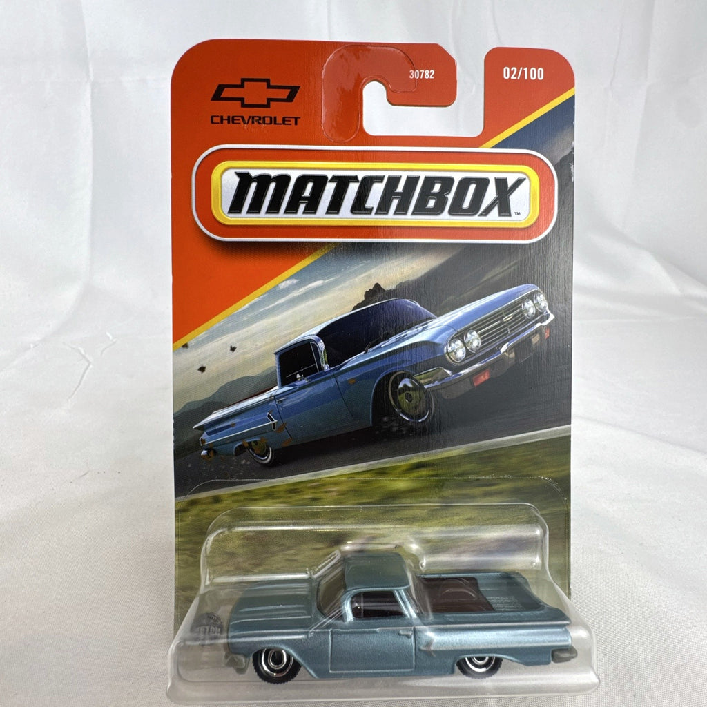 Matchbox 1:64 scale diecast 1960 Chevrolet El Camino pickup truck in metallic light blue unopened blister card packaging.