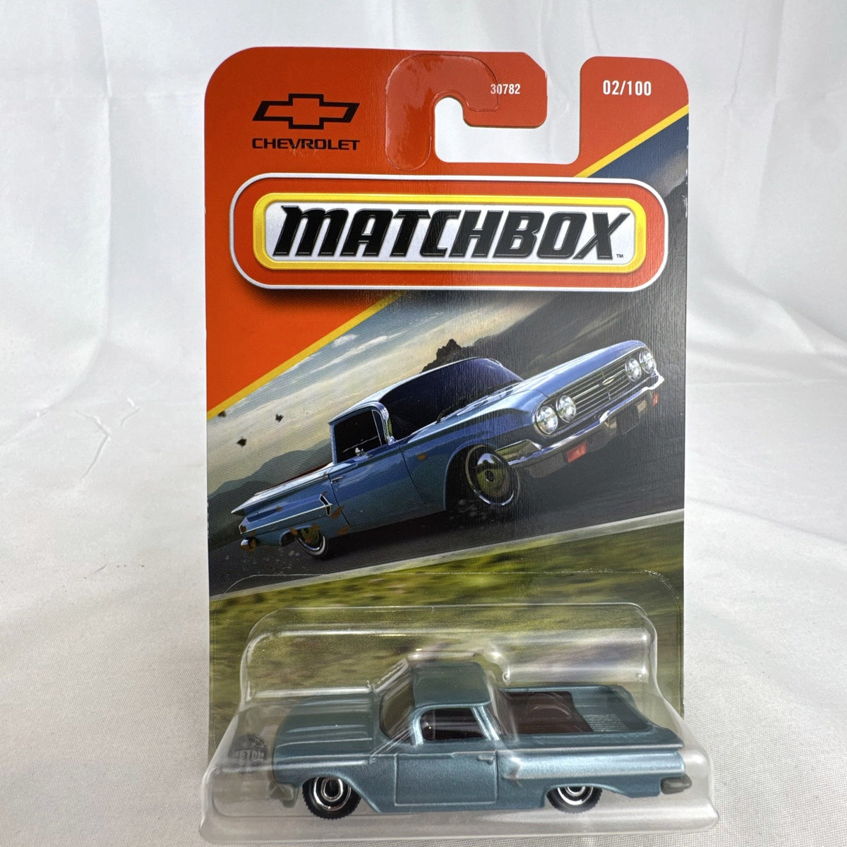 Matchbox 1:64 scale diecast 1960 Chevrolet El Camino pickup truck in metallic light blue unopened blister card packaging.