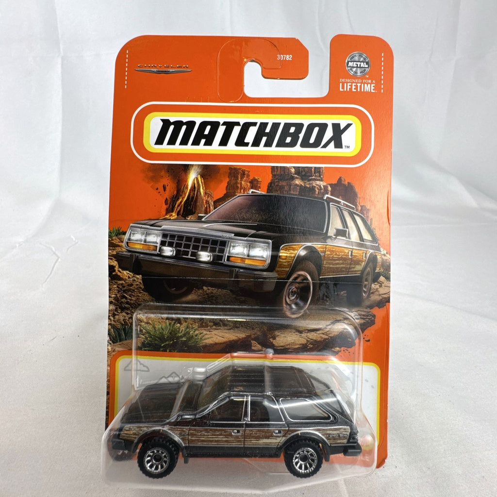 Matchbox 1:64 scale 1980 AMC Eagle diecast station wagon in black with woodgrain side panels sealed on card.