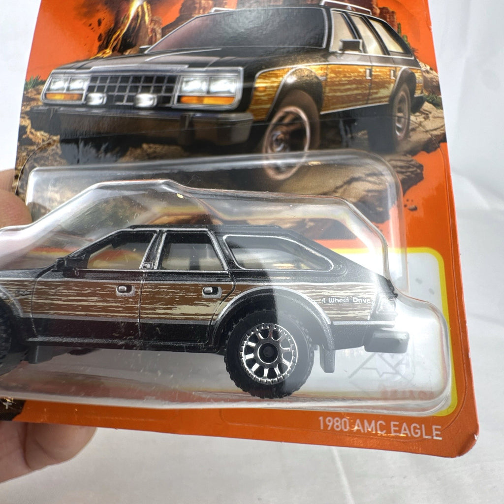Matchbox 1:64 scale 1980 AMC Eagle diecast station wagon in black with woodgrain side panels sealed on card.