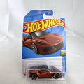 Hot Wheels Factory Fresh 1:64 scale Lotus Emira diecast car in metallic red sealed in original blister pack.