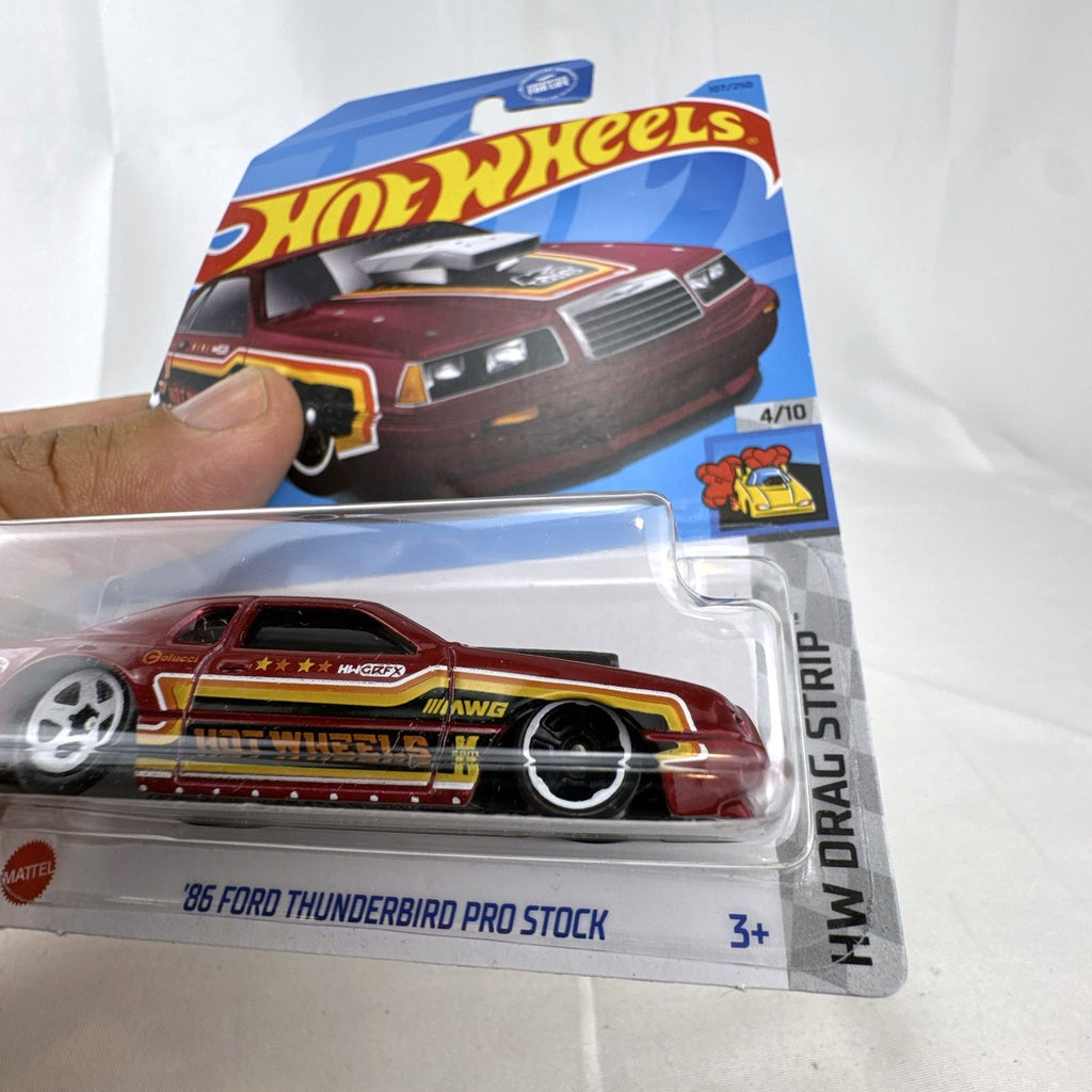 Sealed Hot Wheels 1:64 scale 1986 Ford Thunderbird Pro Stock diecast dragster in dark red metallic packaging.