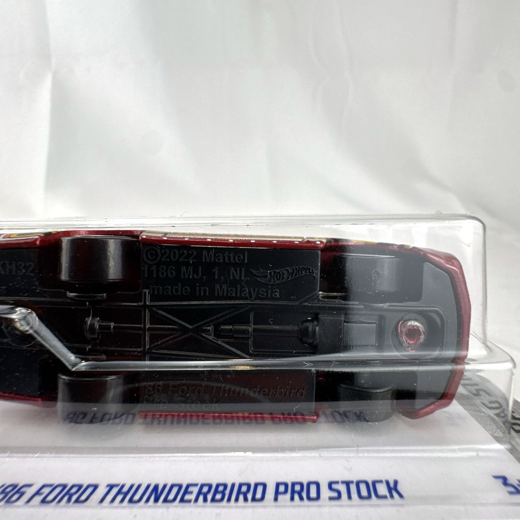 Sealed Hot Wheels 1:64 scale 1986 Ford Thunderbird Pro Stock diecast dragster in dark red metallic packaging.