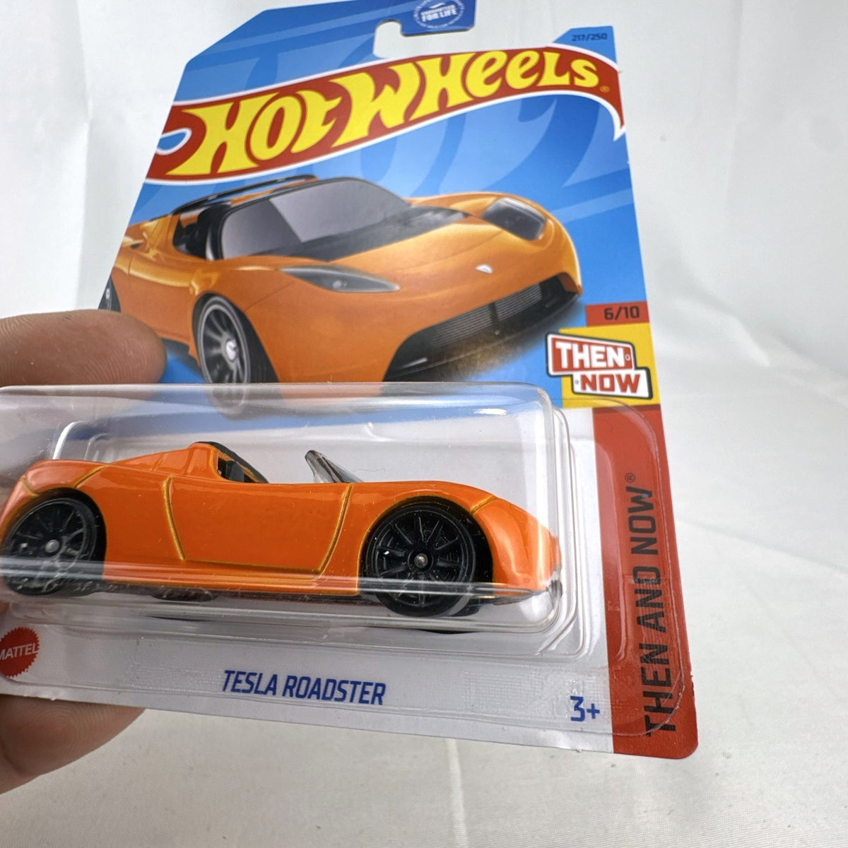 Sealed Hot Wheels 1:64 scale 2008 Tesla Roadster diecast car in vibrant orange on original blister card.