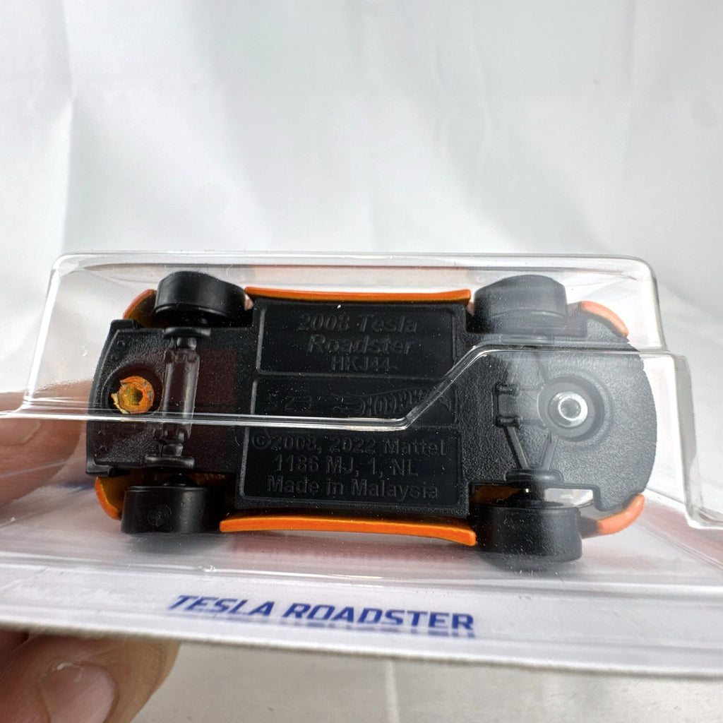 Sealed Hot Wheels 1:64 scale 2008 Tesla Roadster diecast car in vibrant orange on original blister card.