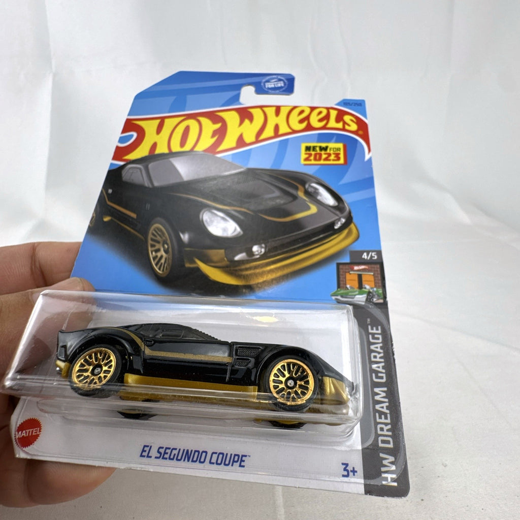 Hot Wheels 1:64 scale 2023 El Segundo Coupe diecast car in black with gold accents, factory sealed on card.