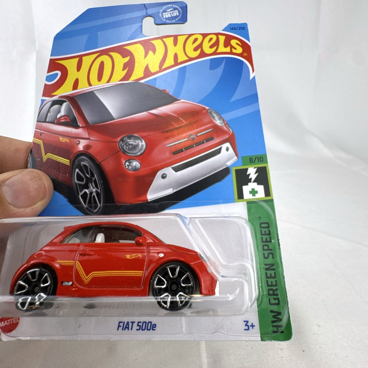 Hot Wheels 1:64 scale FIAT 500e diecast car in red on sealed HW Green Speed blister cardback.
