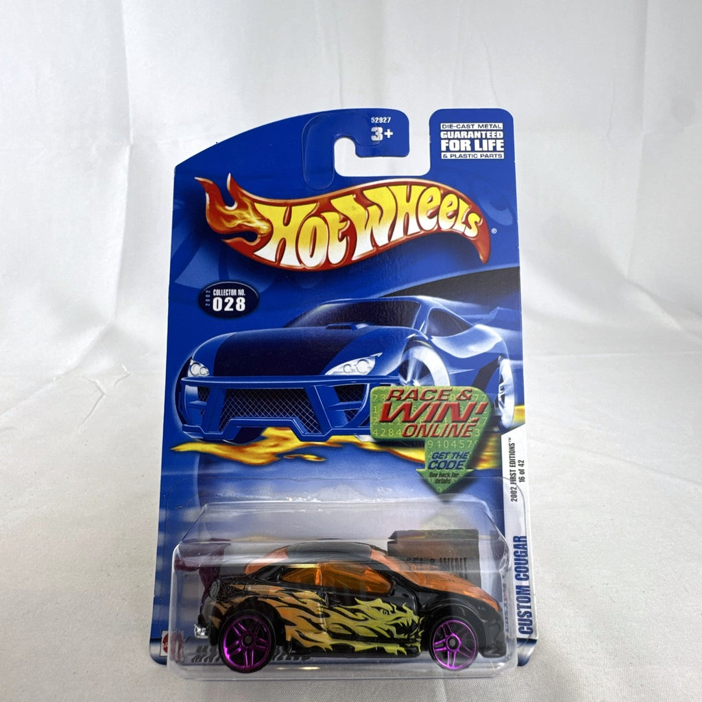 Unopened 2002 Hot Wheels Custom Cougar 1:64 scale diecast car in black with orange dragon flame graphics and purple wheels