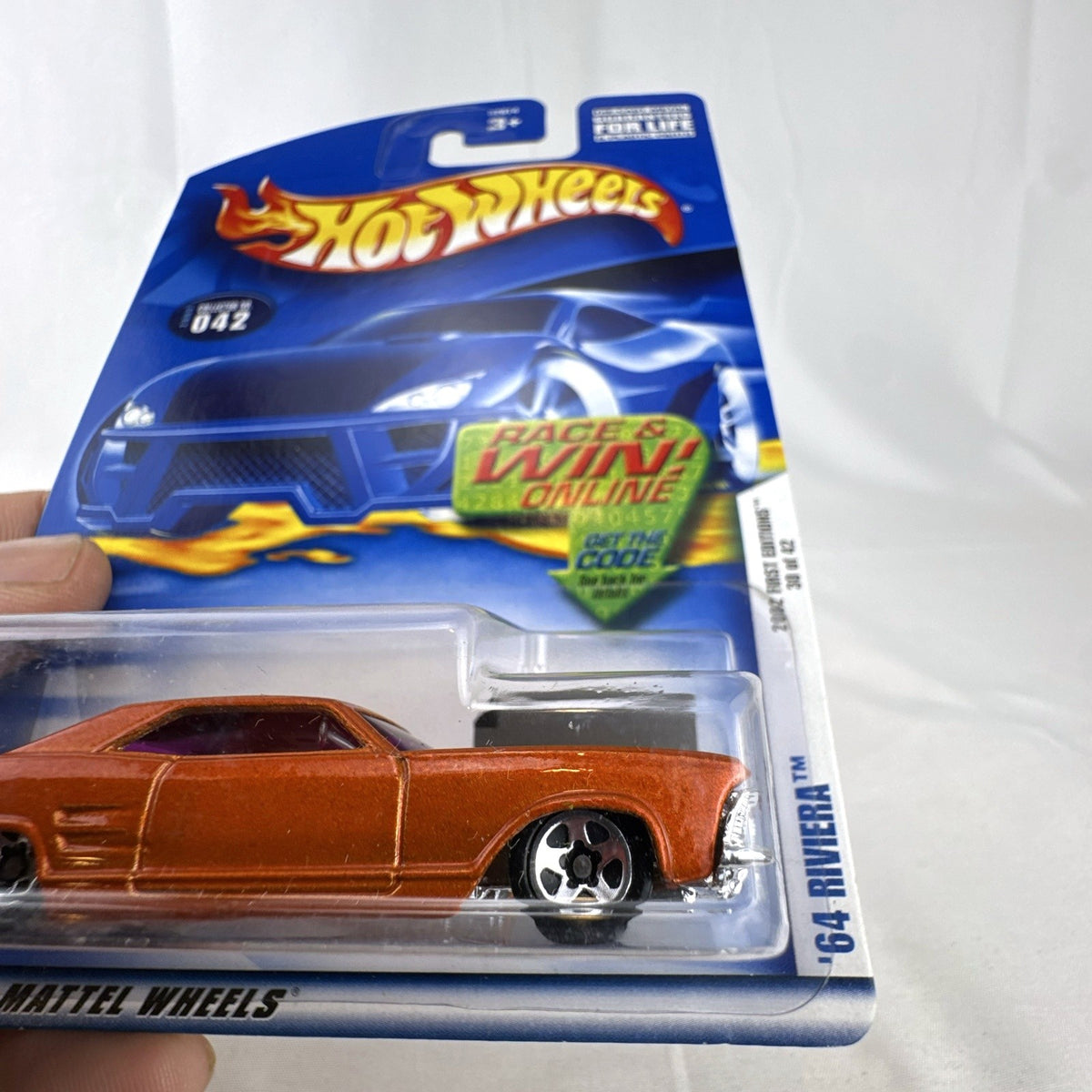 Sealed 2002 Hot Wheels First Editions 1964 Buick Riviera diecast car in metallic orange on blister card.