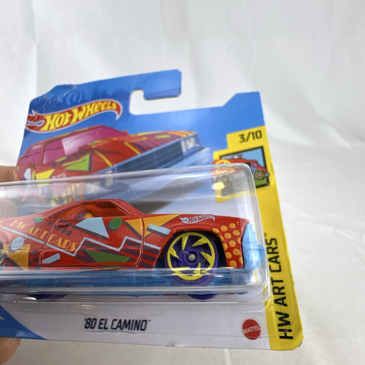 Hot Wheels 1:64 scale 1980 Chevrolet El Camino red diecast toy truck featuring pop-art graphics in sealed card package.