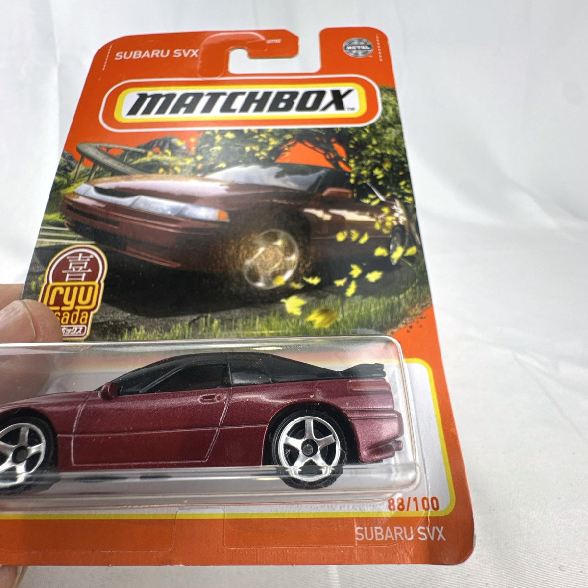Matchbox 1:64 Subaru SVX diecast model car in metallic maroon designed by Ryu Asada