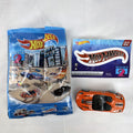 Orange Hot Wheels 1:64 scale 2014 Chevrolet Corvette Stingray diecast car with racing stripes and mystery model packaging.