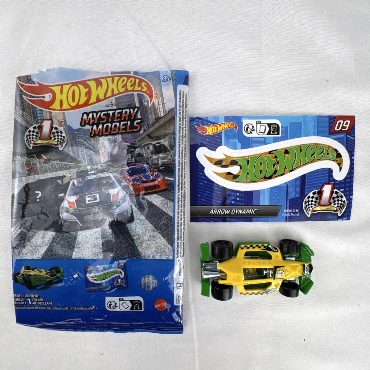Yellow and green Hot Wheels Arrow Dynamic #09 Mystery Models 1:64 scale diecast car with original sticker card.