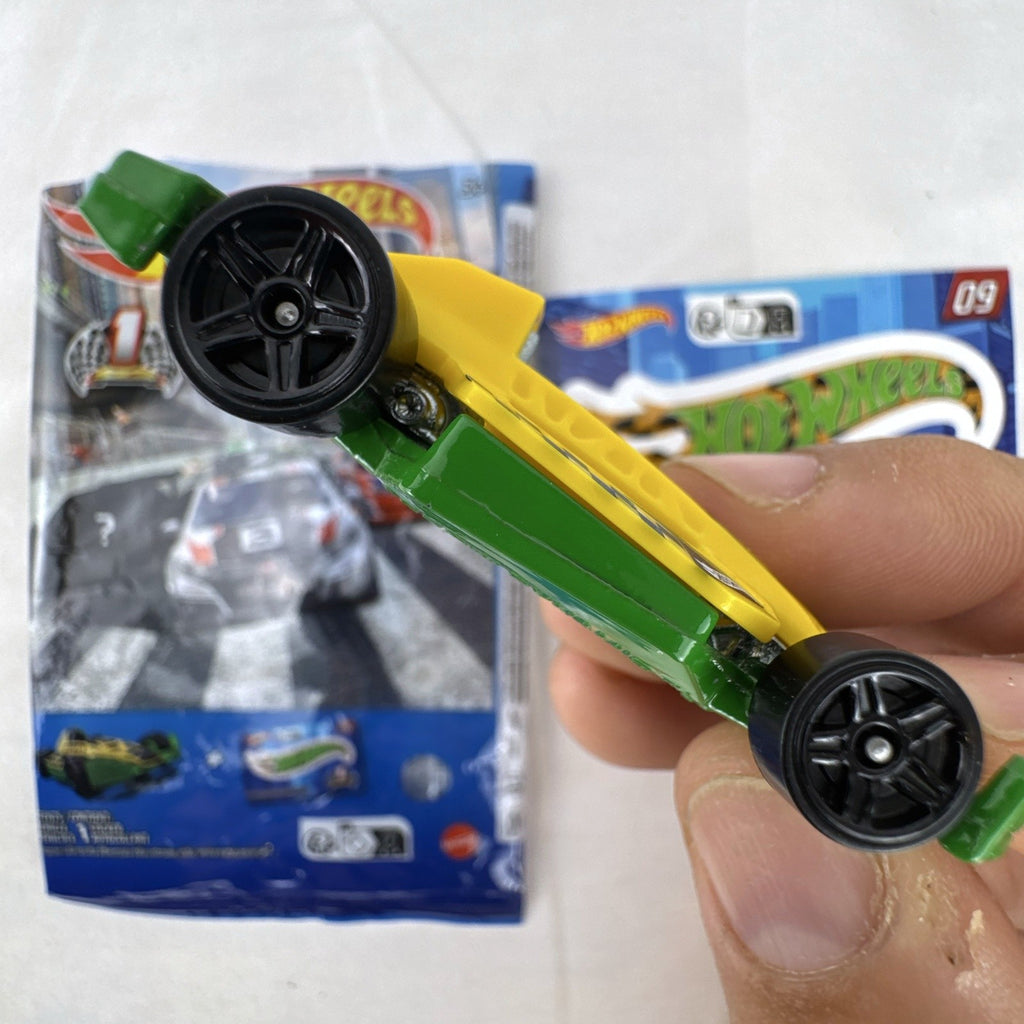 Yellow and green Hot Wheels Arrow Dynamic #09 Mystery Models 1:64 scale diecast car with original sticker card.