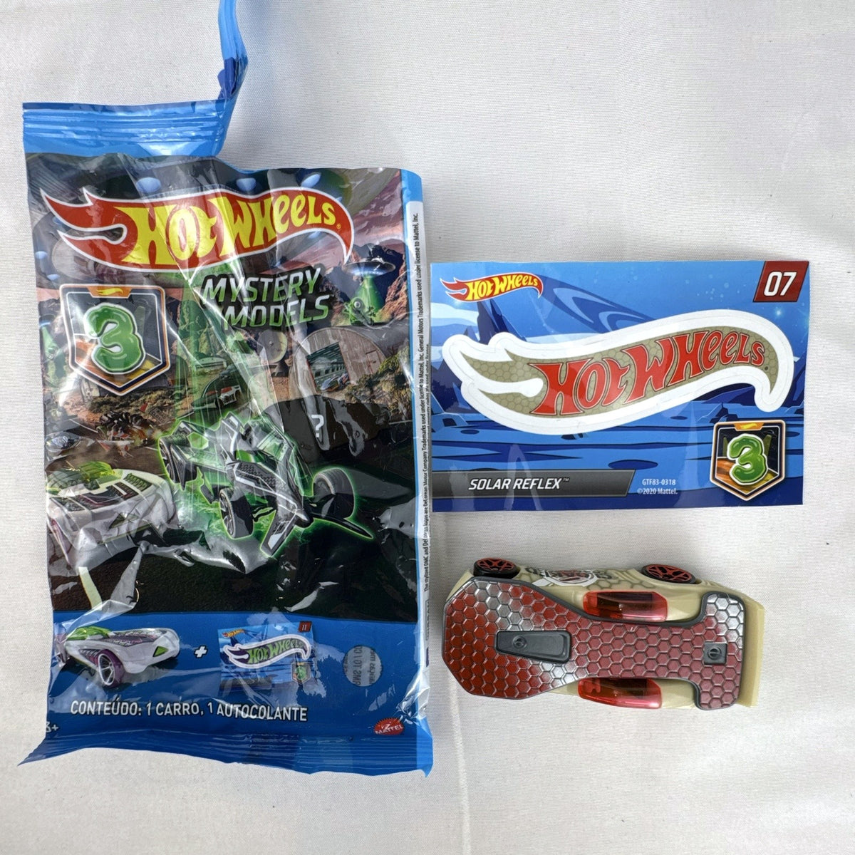 Hot Wheels 1:64 scale Solar Reflex diecast car in tan with red chrome wheels, mystery blind bag, and collector sticker.