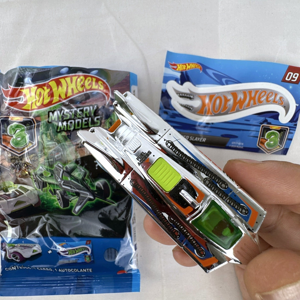 Hot Wheels Speed Slayer 1:64 scale diecast car in chrome with orange base, lime green canopy, foil bag, and sticker.