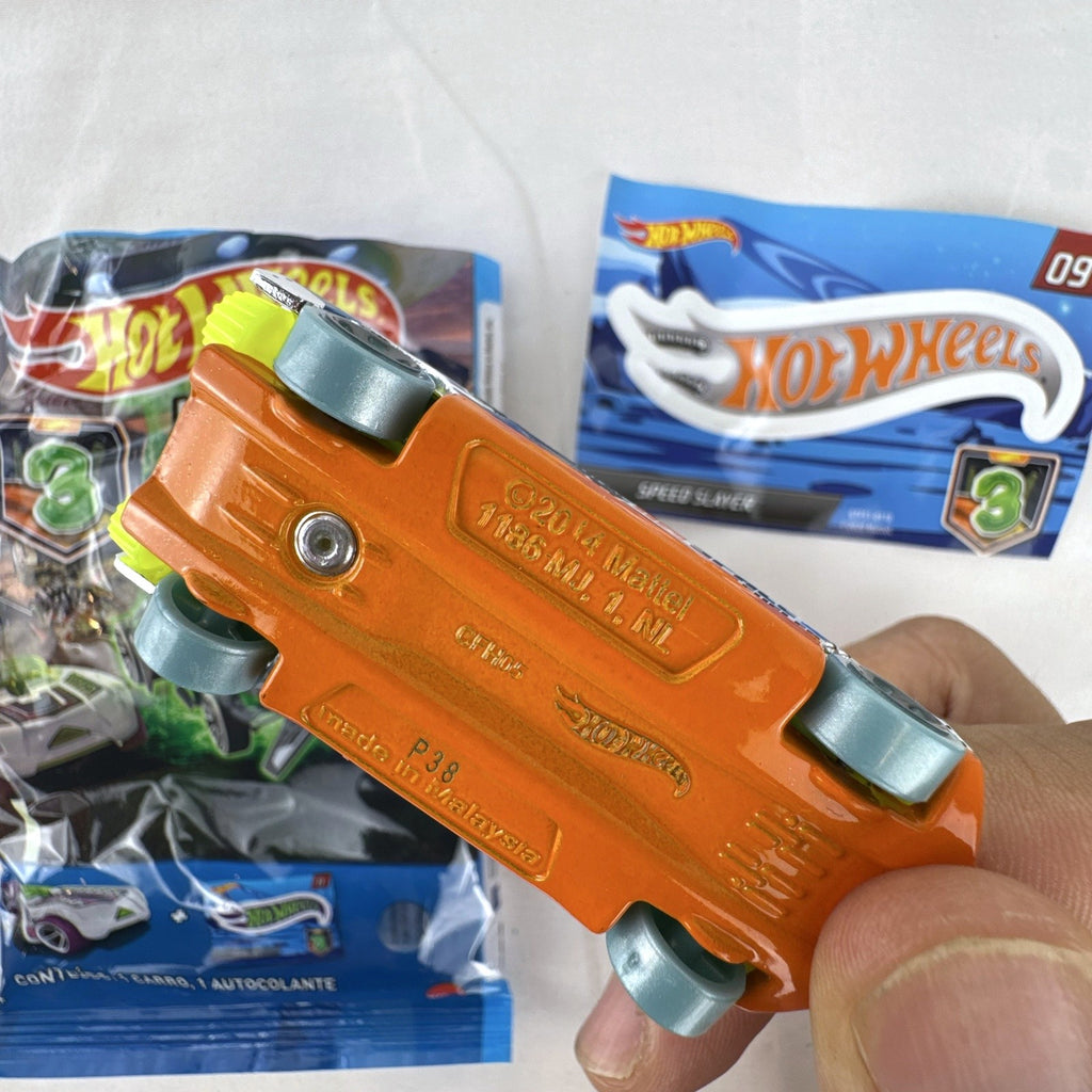 Hot Wheels Speed Slayer 1:64 scale diecast car in chrome with orange base, lime green canopy, foil bag, and sticker.