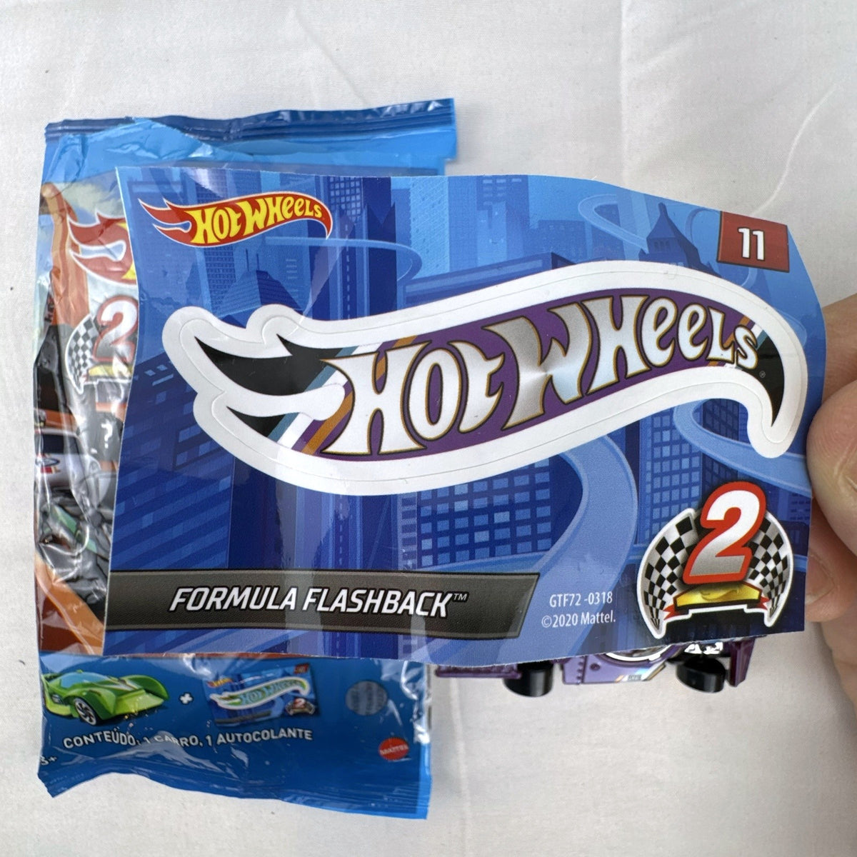 Hot Wheels Formula Flashback 1:64 scale purple diecast racer with gold wheels and matching sticker.