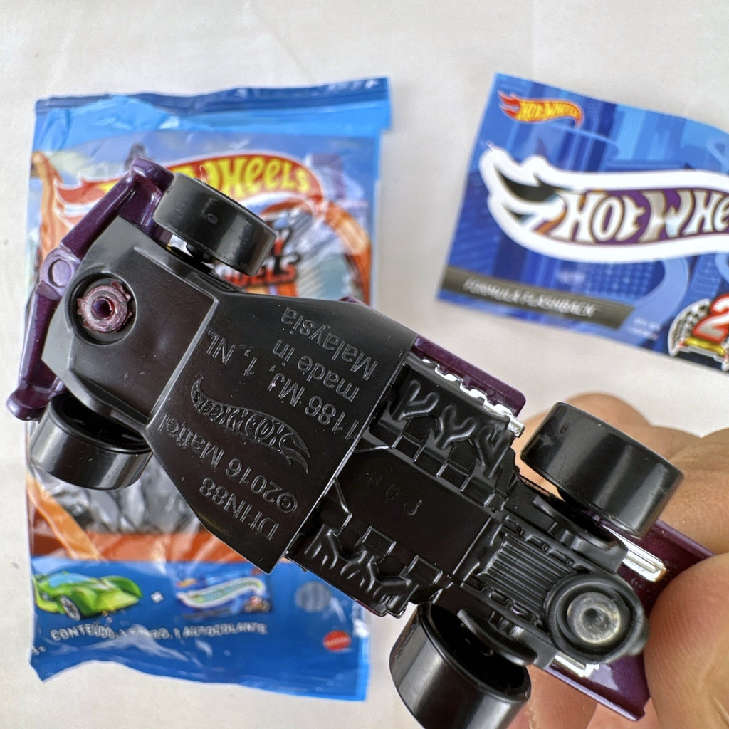 Hot Wheels Formula Flashback 1:64 scale purple diecast racer with gold wheels and matching sticker.
