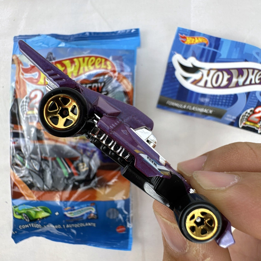 Hot Wheels Formula Flashback 1:64 scale purple diecast racer with gold wheels and matching sticker.