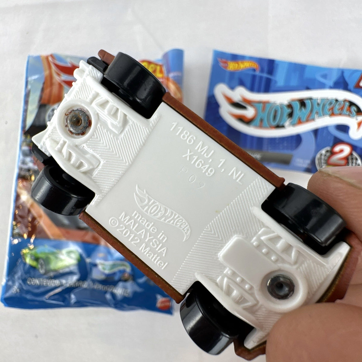 Hot Wheels 1:64 scale Loop Coupe diecast car in satin brown with HW Racing graphics and original foil packaging.