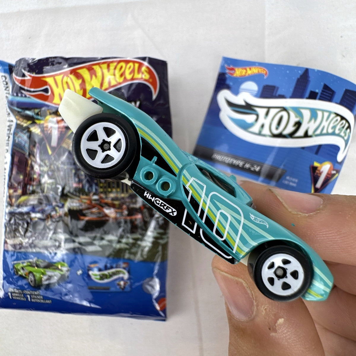 Teal Hot Wheels Prototype H-24 diecast 1:64 scale car with number 10 racing graphics and white 5-spoke wheels.