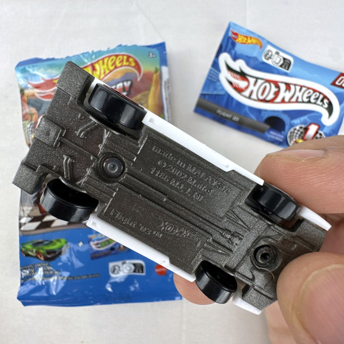 Hot Wheels 1:64 scale Flight '03 diecast car in black with katakana graphics and included sticker from 2024 Mystery Models.