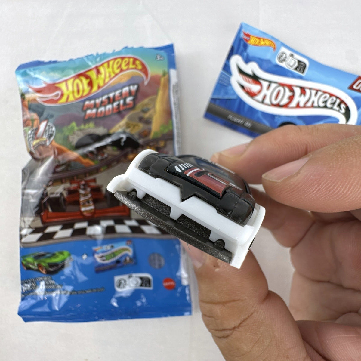 Hot Wheels 1:64 scale Flight '03 diecast car in black with katakana graphics and included sticker from 2024 Mystery Models.