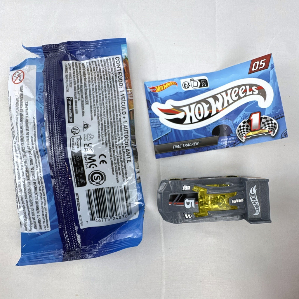 Dark gray Hot Wheels Time Tracker diecast car 1:64 scale with yellow wheels and mystery models sticker sheet.