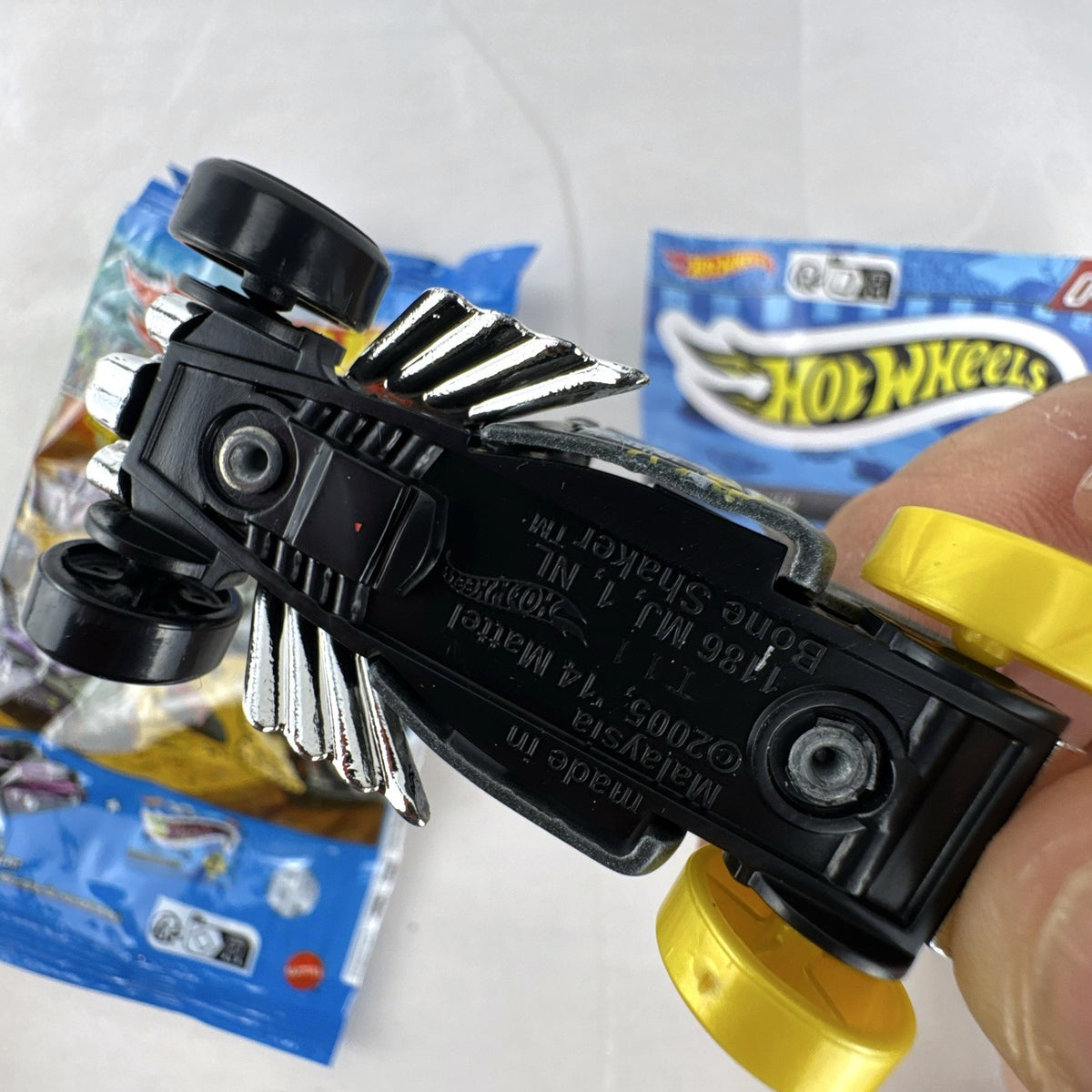 Hot Wheels 1:64 scale satin dark gray Bone Shaker mystery model diecast car with original mystery pouch and sticker