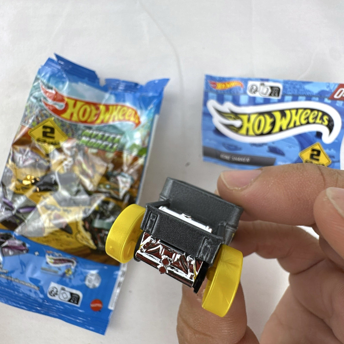 Hot Wheels 1:64 scale satin dark gray Bone Shaker mystery model diecast car with original mystery pouch and sticker