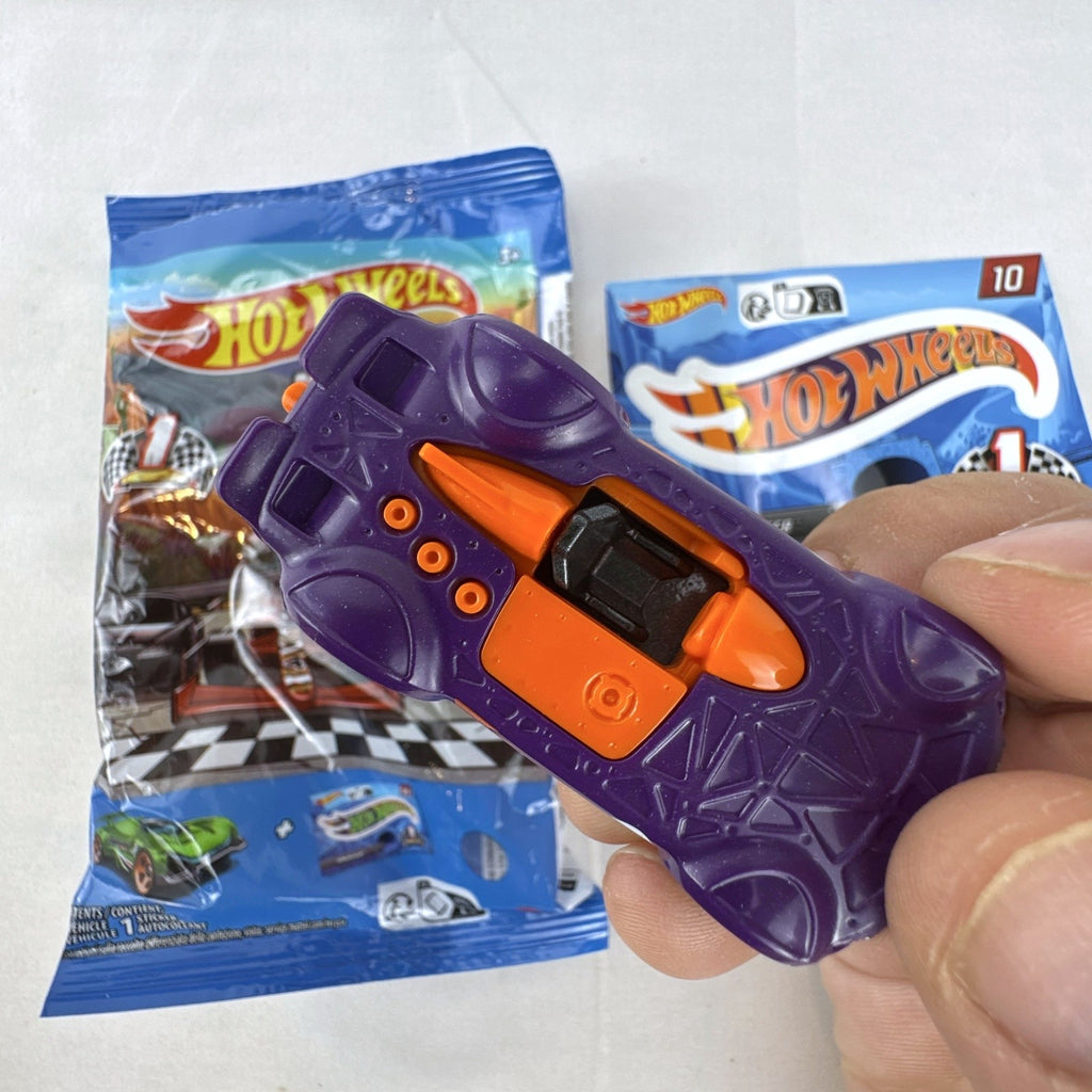 Hot Wheels 1:64 scale Monteracer diecast car in purple and orange from Mystery Models Series 1 with original bag and sticker.