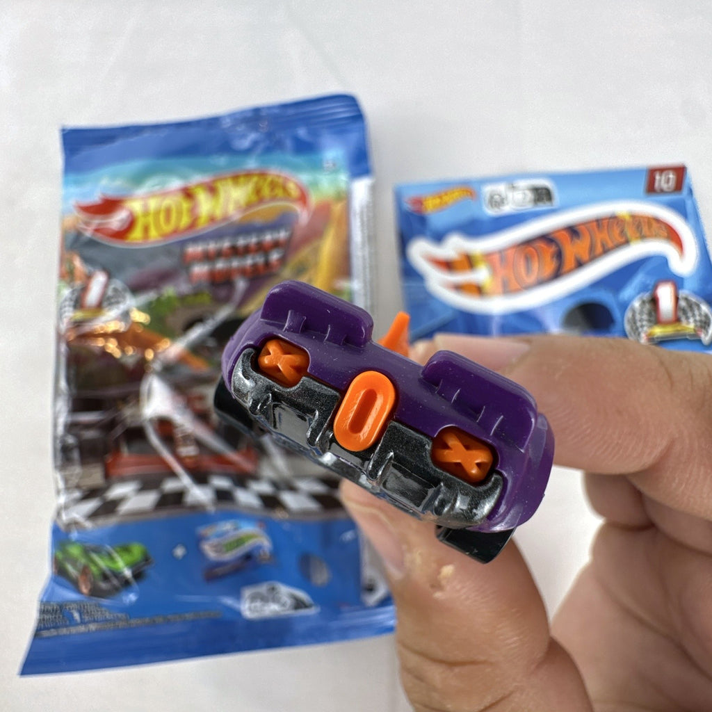 Hot Wheels 1:64 scale Monteracer diecast car in purple and orange from Mystery Models Series 1 with original bag and sticker.