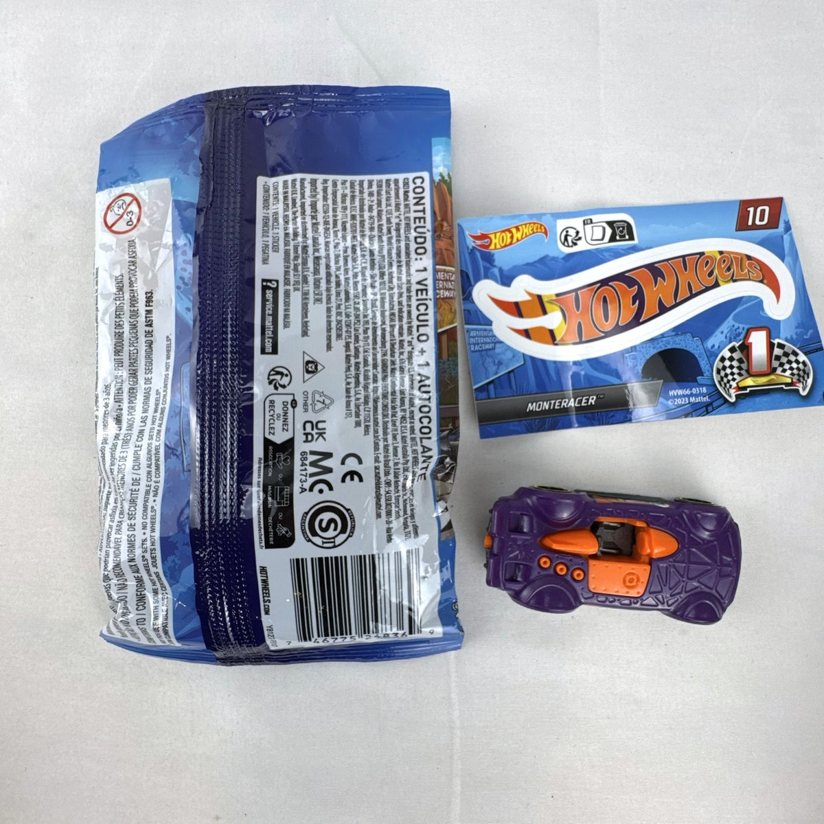 Hot Wheels 1:64 scale Monteracer diecast car in purple and orange from Mystery Models Series 1 with original bag and sticker.