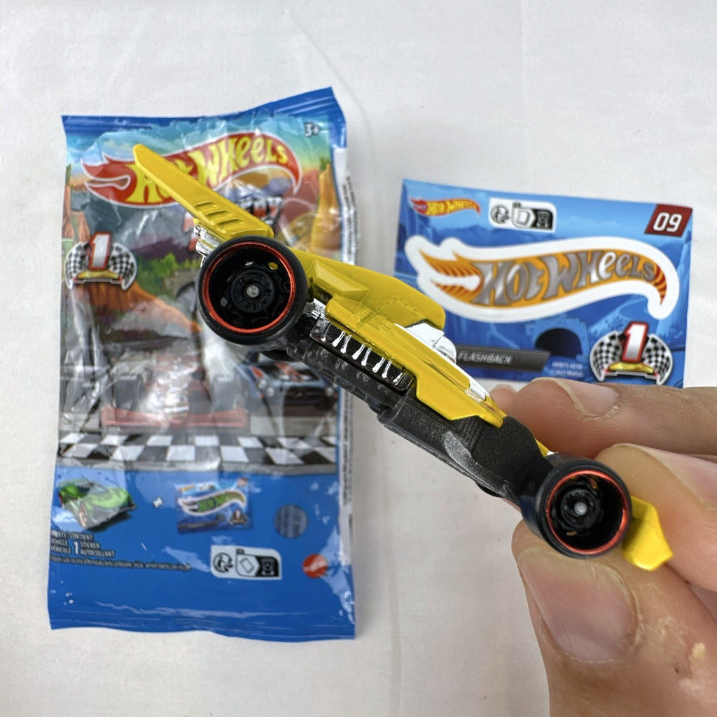 Hot Wheels 1:64 scale Formula Flashback Mystery Models Series 1 yellow diecast racer with sticker card and opened foil pouch