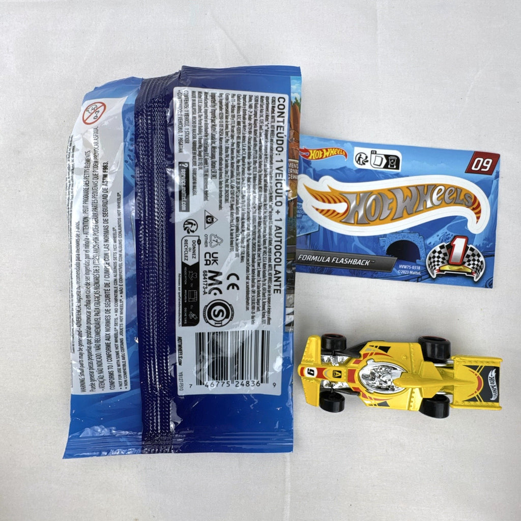 Hot Wheels 1:64 scale Formula Flashback Mystery Models Series 1 yellow diecast racer with sticker card and opened foil pouch