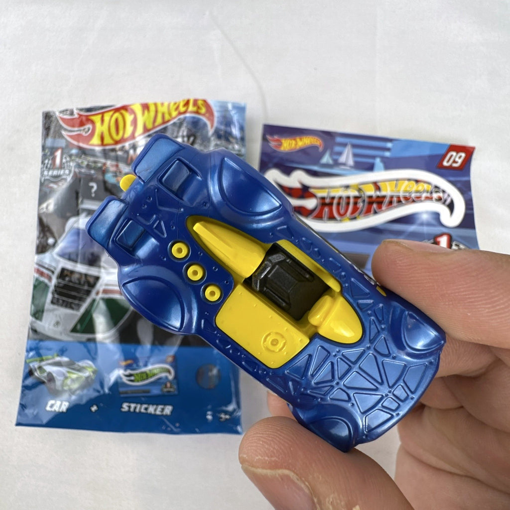 Blue 1:64 scale Hot Wheels Monteracer #09 Mystery Models diecast car with red and yellow graphics.