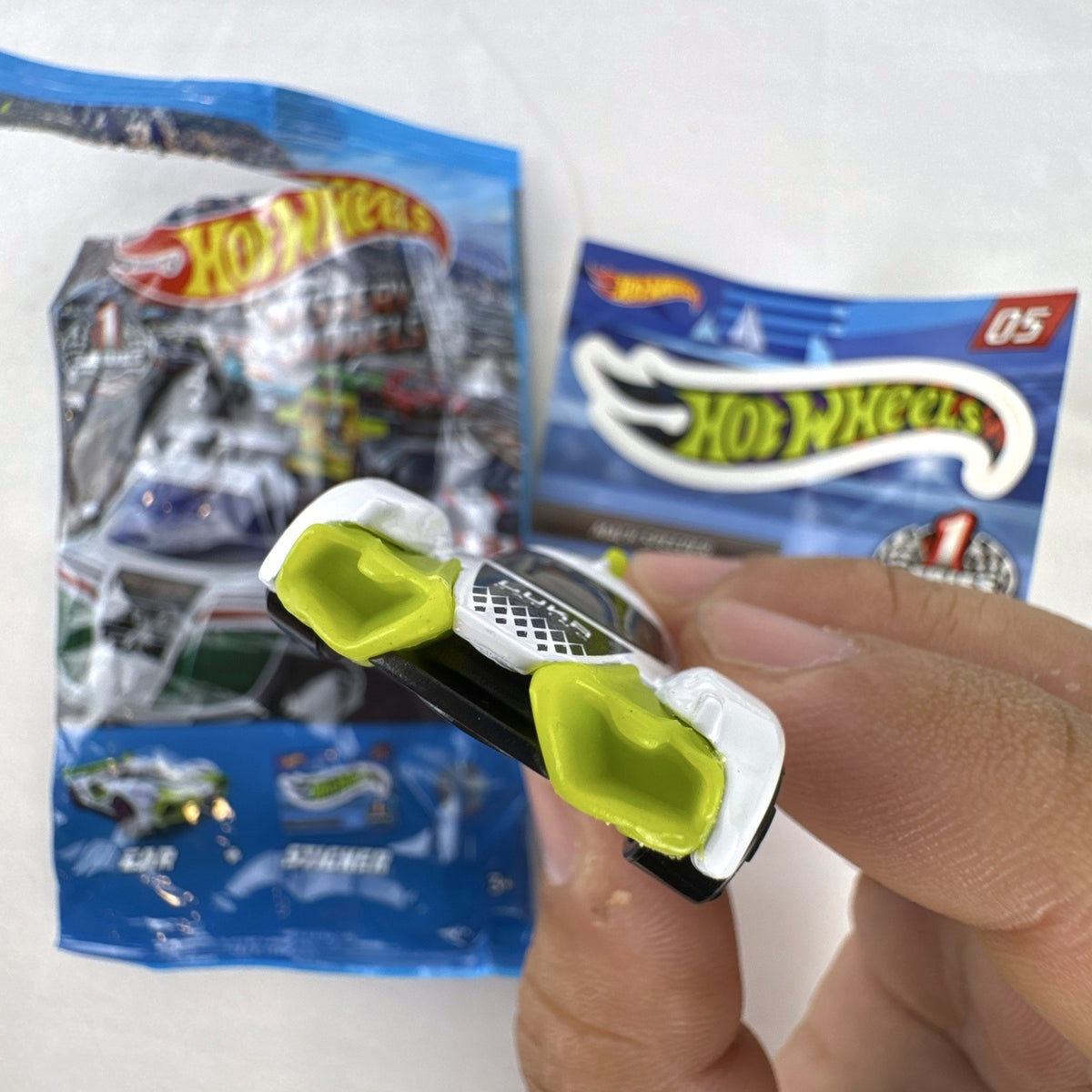 White Hot Wheels Mach Speeder diecast car Mystery Models #05 with purple graphics and lime green accents