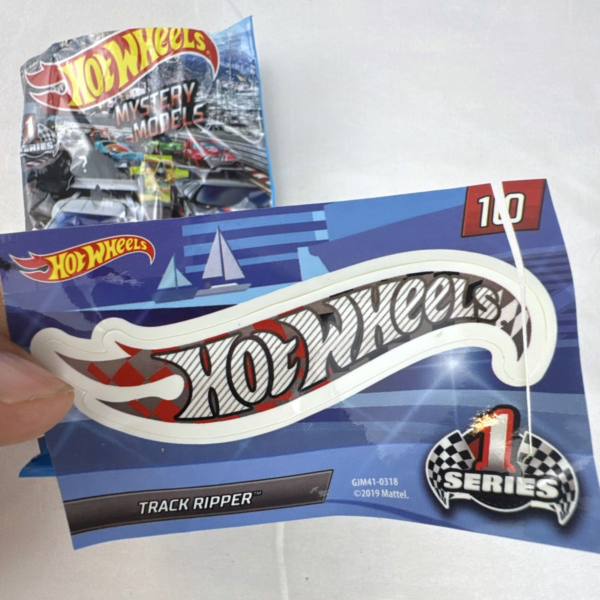 Hot Wheels Track Ripper 1:64 scale diecast car in silver with red racing graphics and matching #10 sticker.