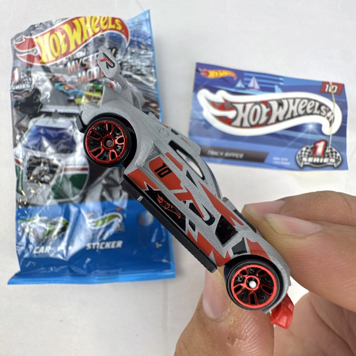 Hot Wheels Track Ripper 1:64 scale diecast car in silver with red racing graphics and matching #10 sticker.