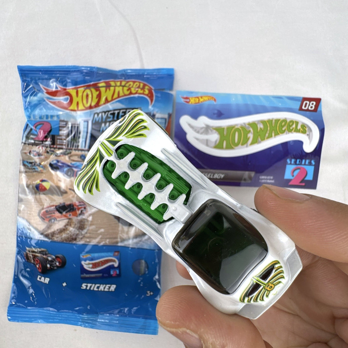 Hot Wheels 1:64 scale Dieselboy diecast car in white and green with original 2020 Mystery Models Series 2 bag and sticker card.